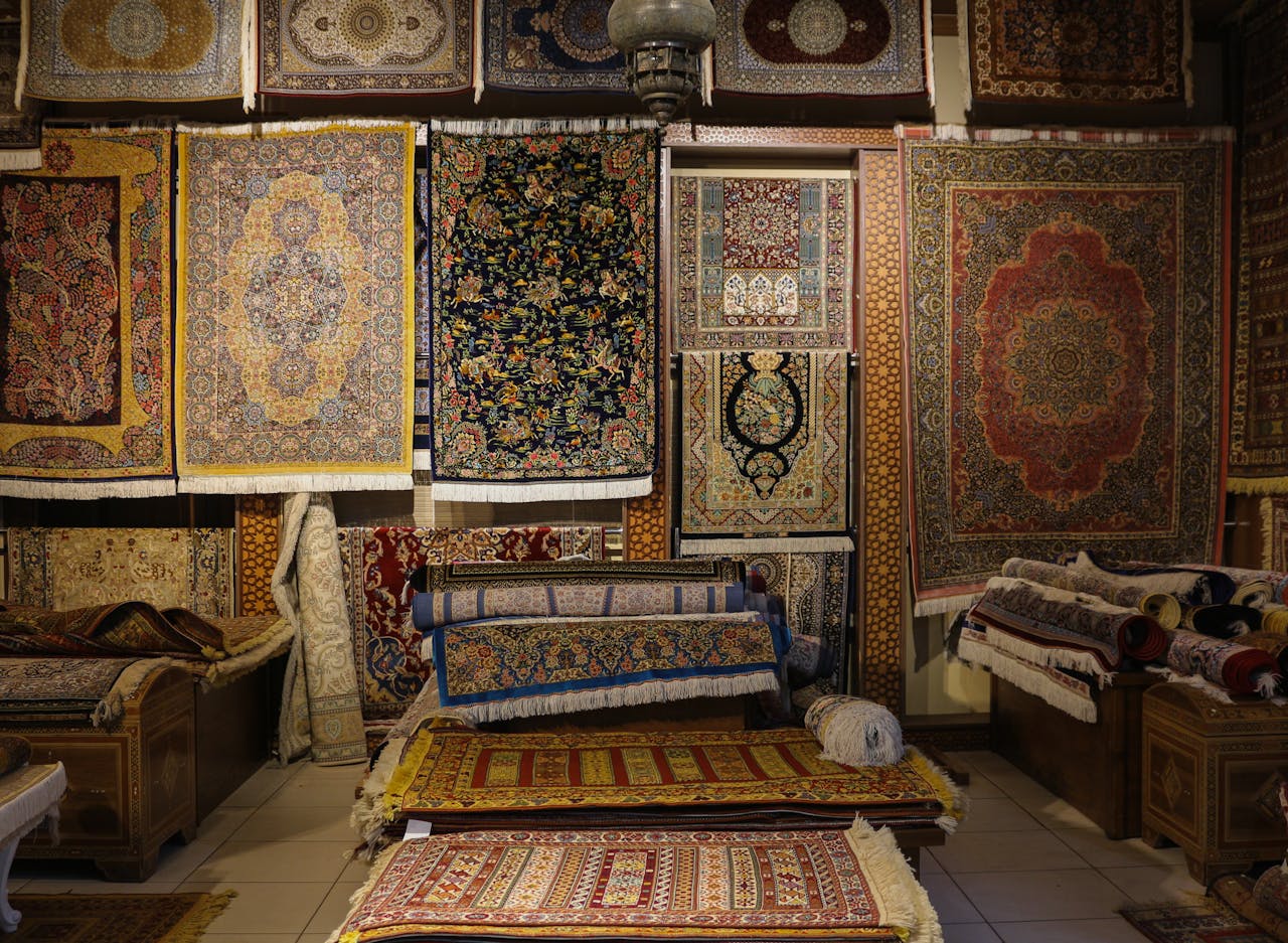our-services-2 A captivating display of intricately designed traditional rugs in a cozy shop.